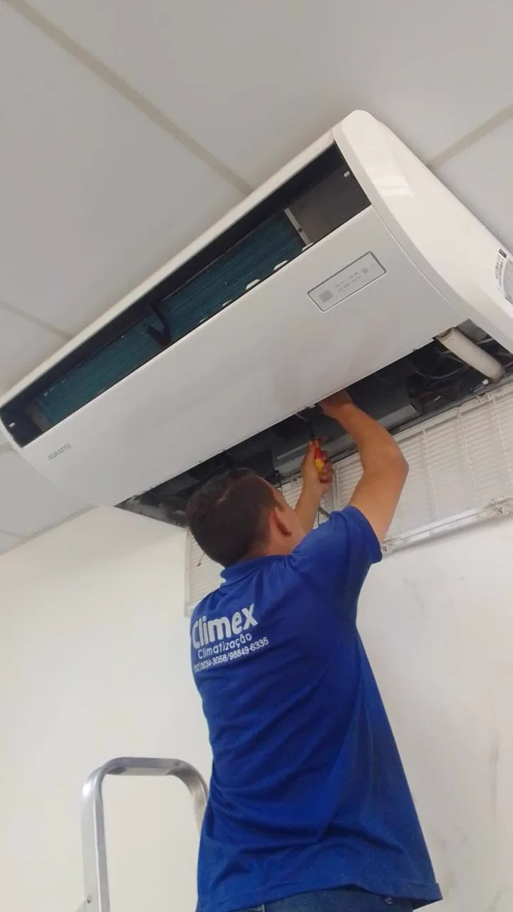 Técnico uniformizado da Climex trabalhando em aparelho de ar-condicionado